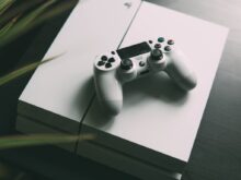 selective focus photography of white Sony PS4 console with wireless controller