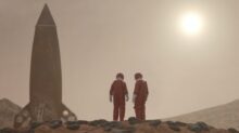 3 men standing on rocky shore during daytime