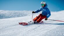 man ice skiing on hill
