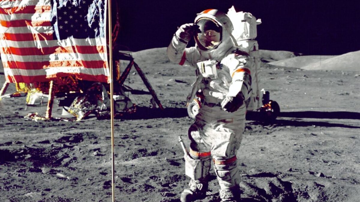 astronaut standing on moon beside U.S.A. flag