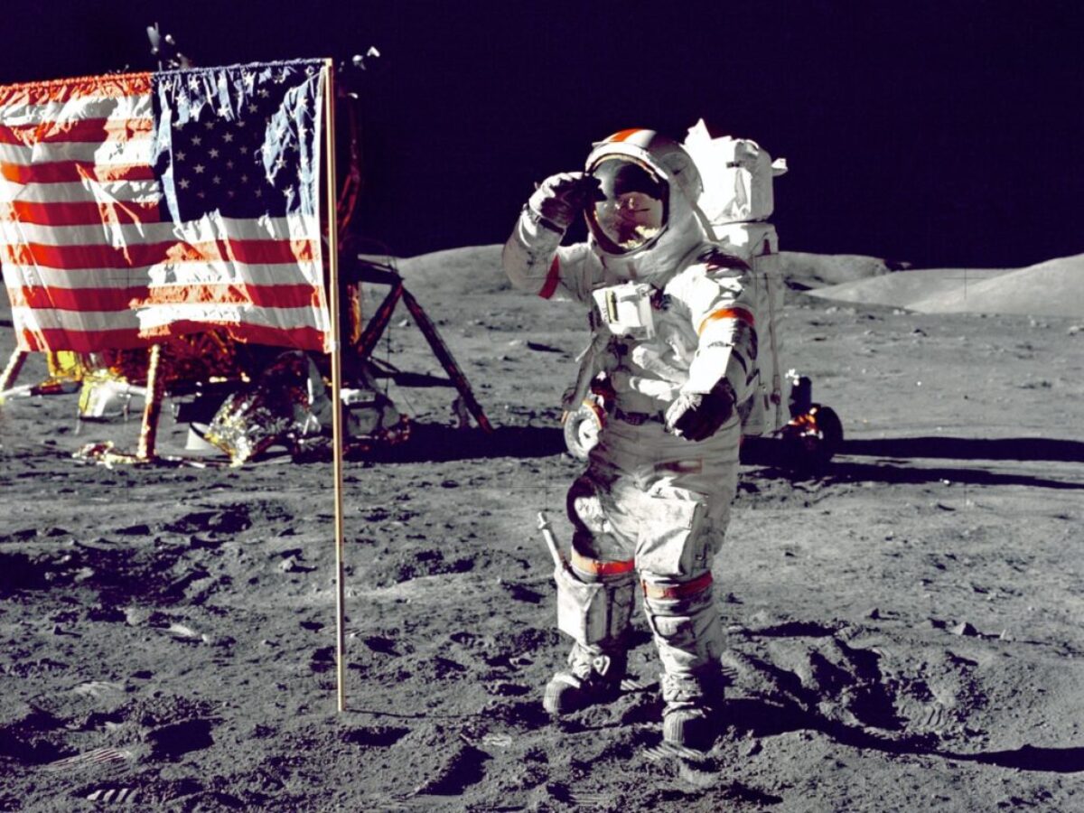 astronaut standing on moon beside U.S.A. flag