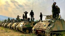 soldiers on top of battle tanks