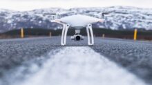 white quadcopter on gray concrete road top during daytime
