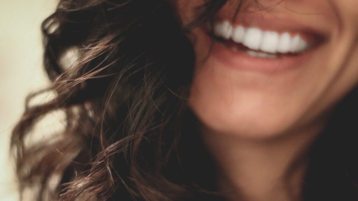 long black haired woman smiling close-up photography