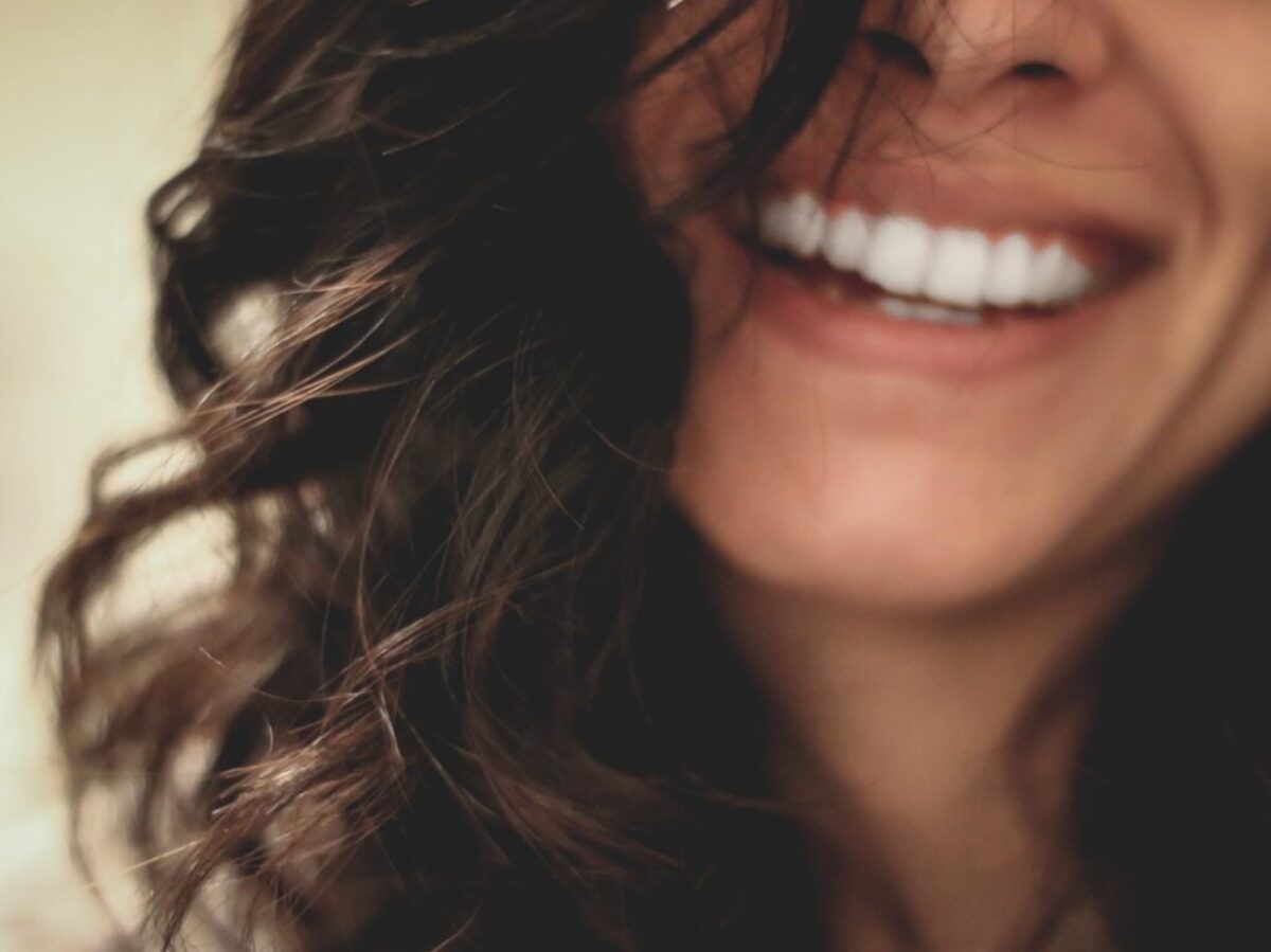 long black haired woman smiling close-up photography