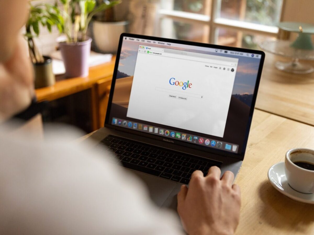 person using macbook pro on table