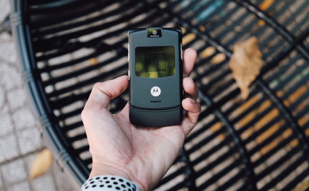 black samsung flip phone on persons hand