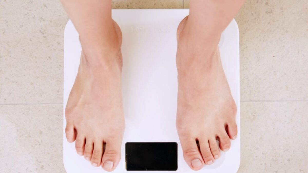 person standing on white digital bathroom scale