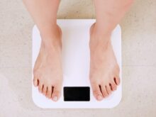 person standing on white digital bathroom scale
