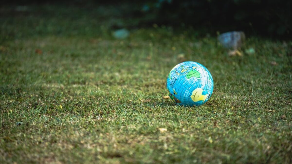 blue and white desk globe on green grass field during daytime