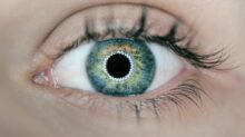 person showing green and black eyelid closeup photography