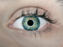 person showing green and black eyelid closeup photography