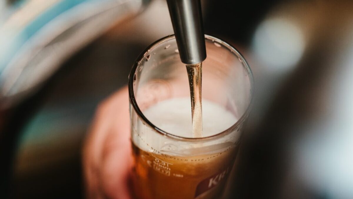 person filling clear glass with liquid