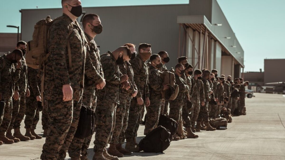 men in black and brown camouflage uniform standing on brown floor