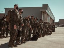 men in black and brown camouflage uniform standing on brown floor
