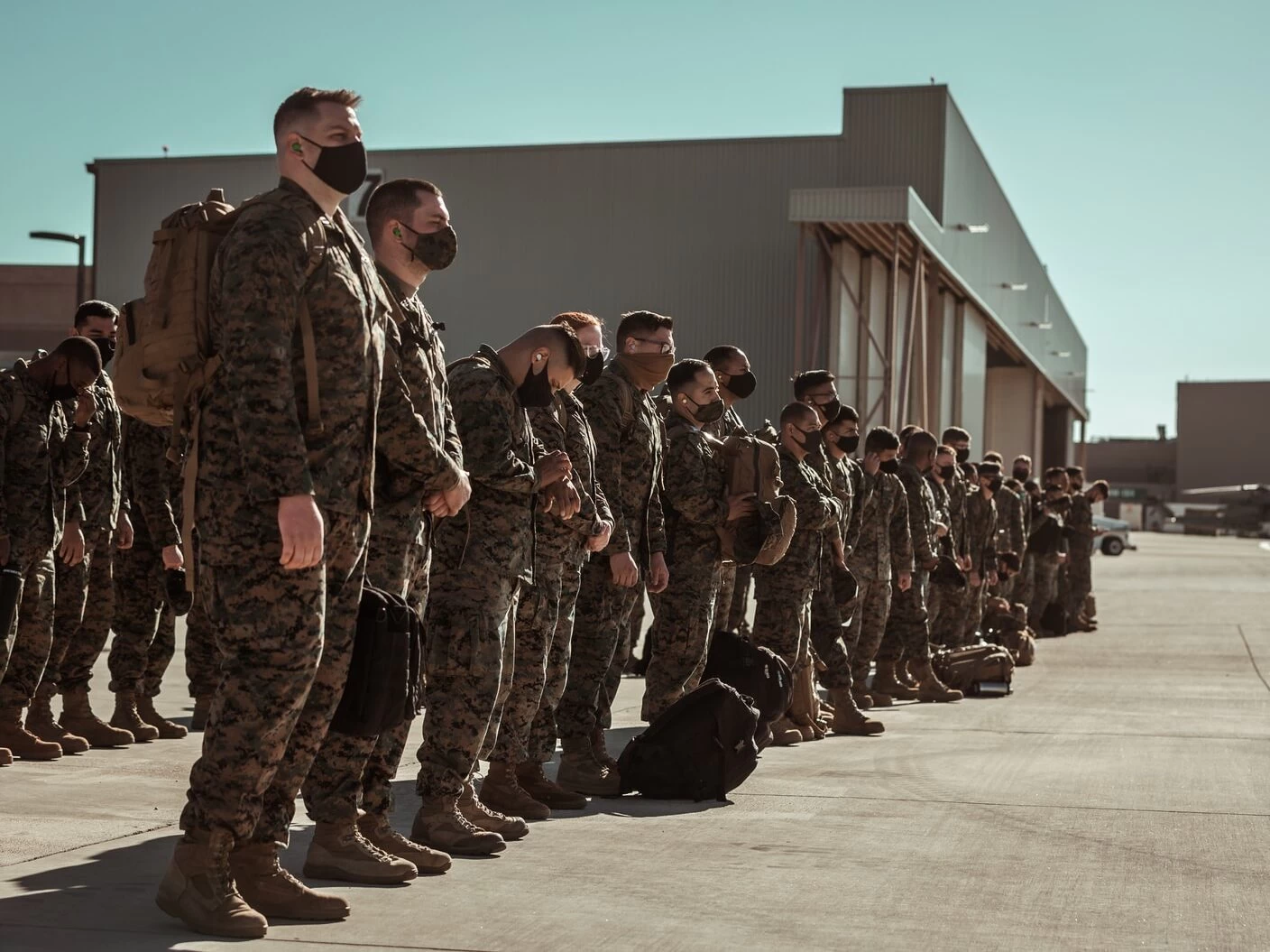 men in black and brown camouflage uniform standing on brown floor