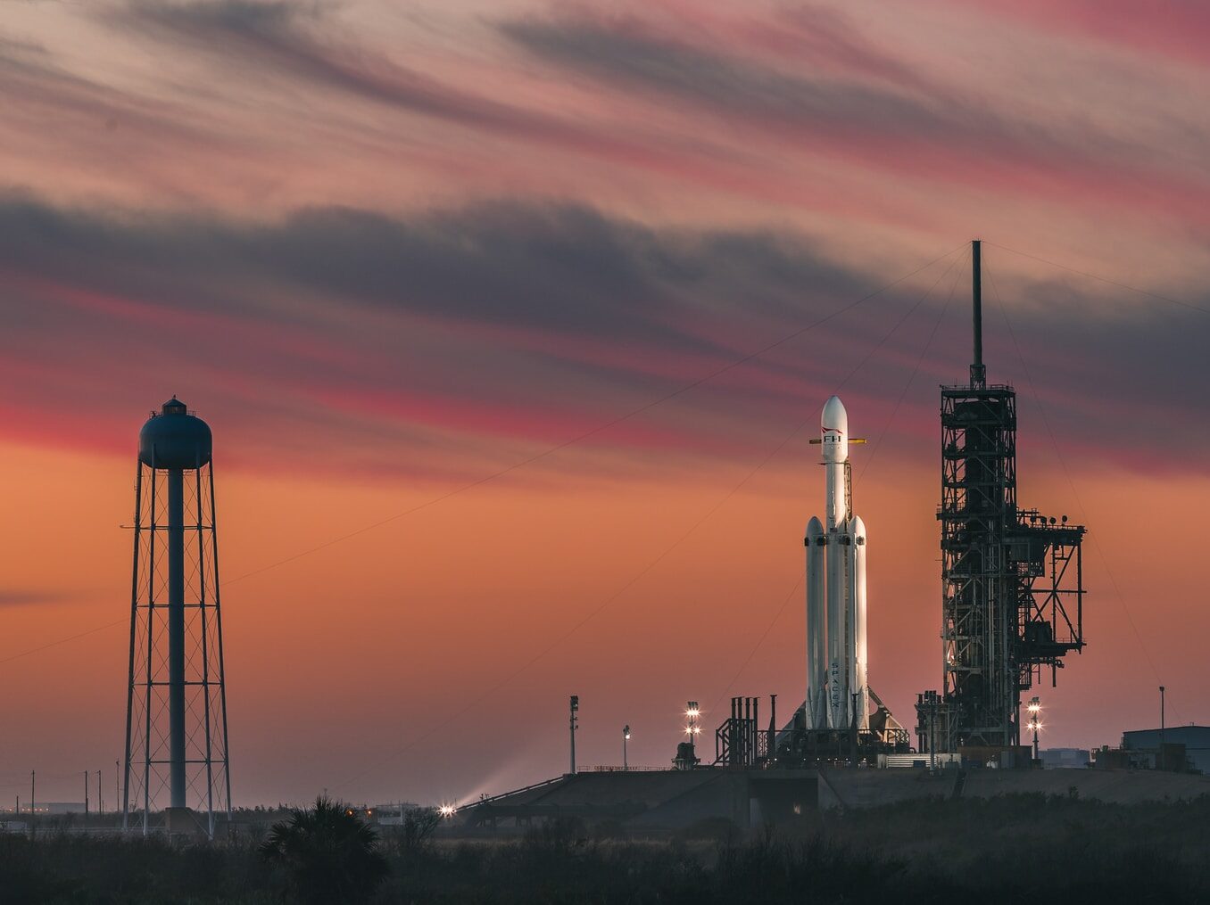 white rocket under nimbus clouds at golden hour