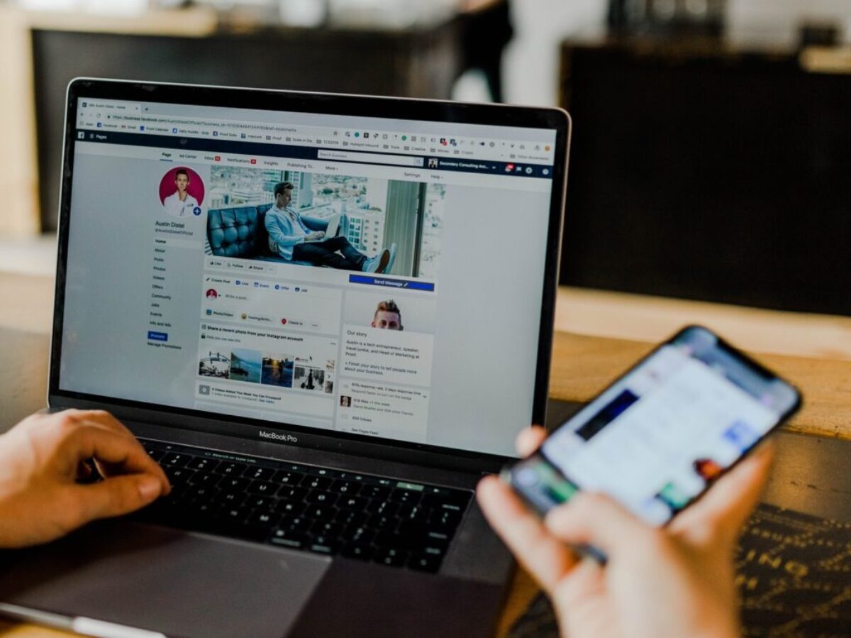 person using both laptop and smartphone