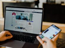 person using both laptop and smartphone