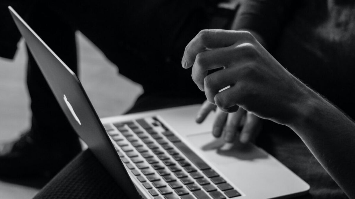 grayscale photo of person using MacBook