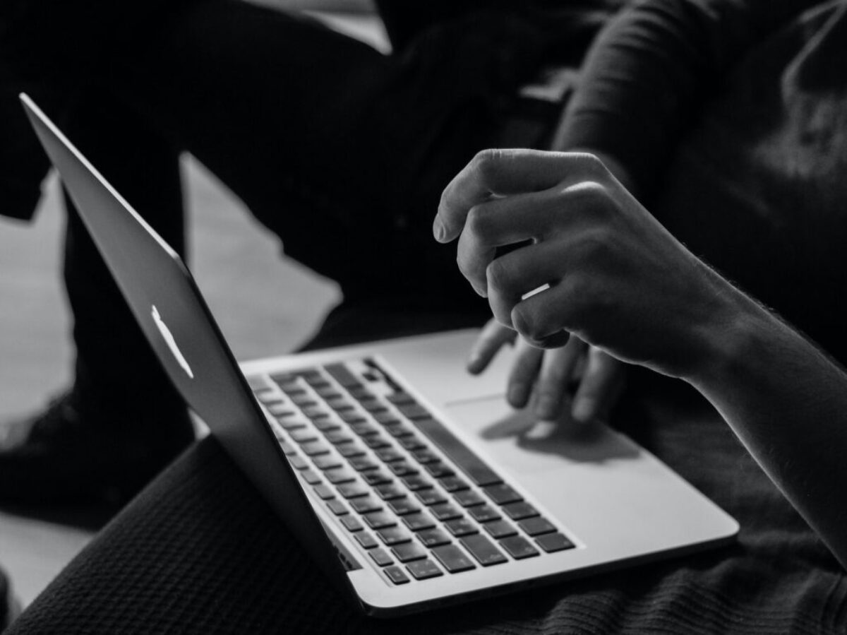 grayscale photo of person using MacBook