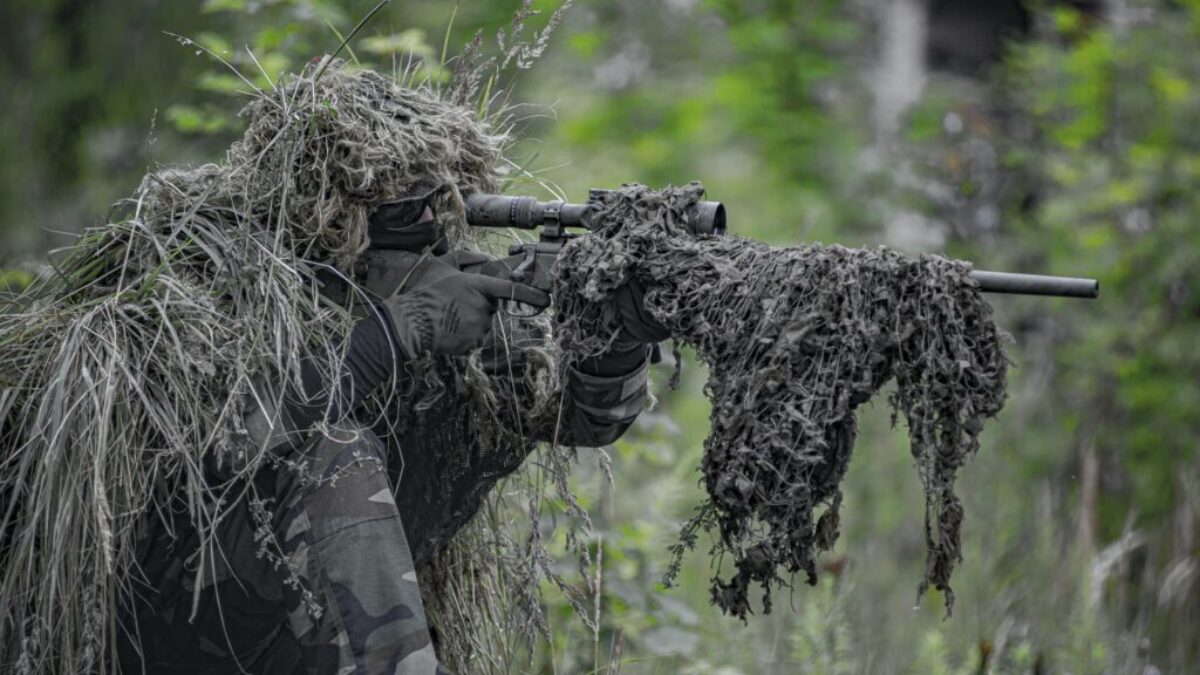 sniper wearing a ghillie in selective focus photography