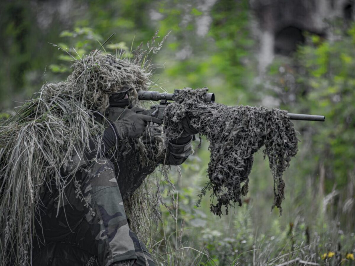 sniper wearing a ghillie in selective focus photography