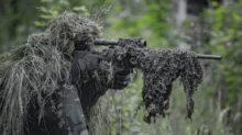 sniper wearing a ghillie in selective focus photography