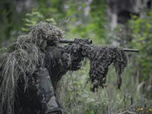 sniper wearing a ghillie in selective focus photography