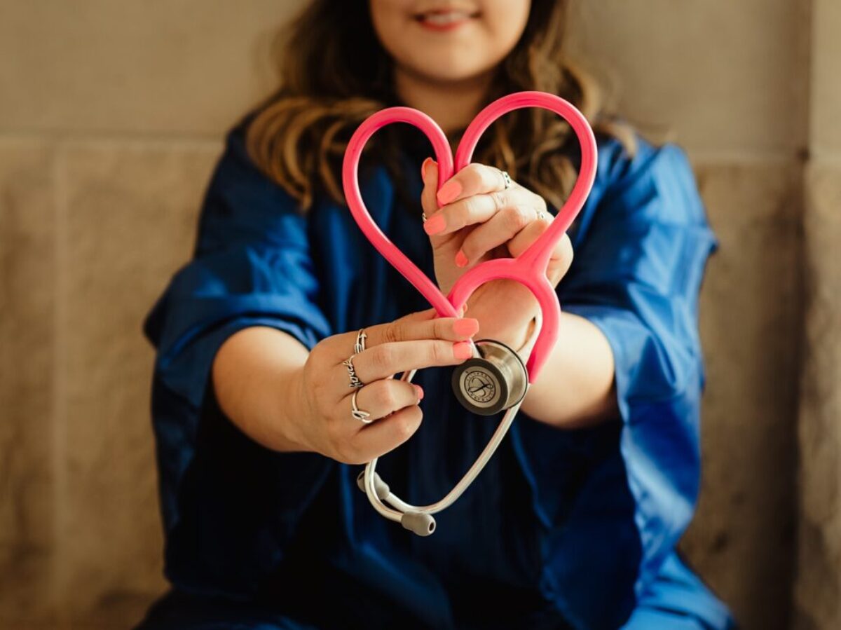 girl in blue jacket holding red and silver ring