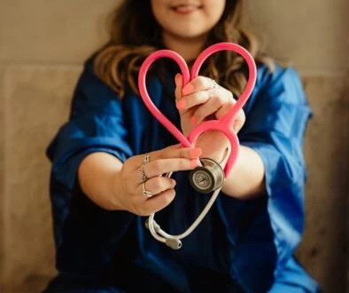 girl in blue jacket holding red and silver ring