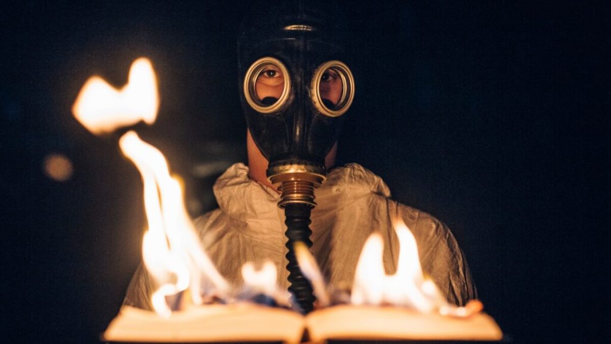 person wearing gas mask holding fire