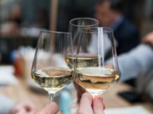 three people having a toast using three clear crystal wine glasses