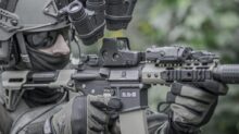 person holding grey and black rifle