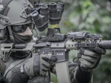 person holding grey and black rifle