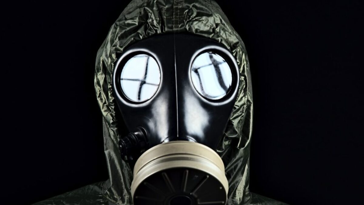 person in green and black gas mask
