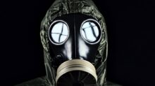 person in green and black gas mask
