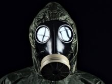 person in green and black gas mask