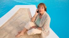 woman in brown coat sitting on brown wooden dock