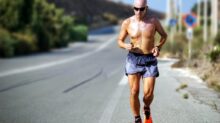 man jogging while listening using black earphones during day time