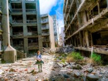 woman wearing white and green dress surrounded by storey buildings