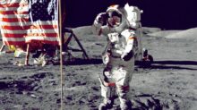 astronaut standing on moon beside U.S.A. flag