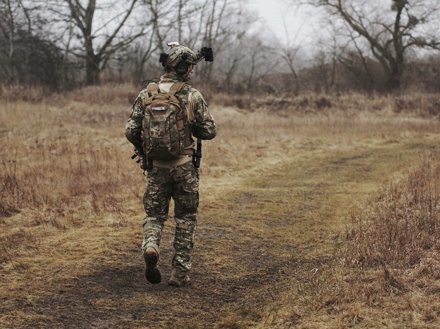 man walking on brown grass field