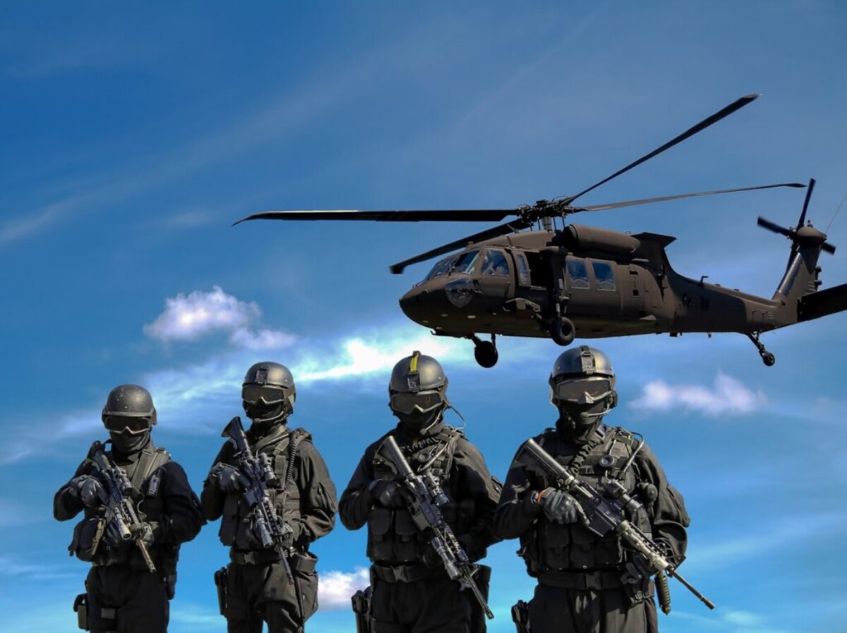 Four Soldiers Carrying Rifles Near Helicopter Under Blue Sky