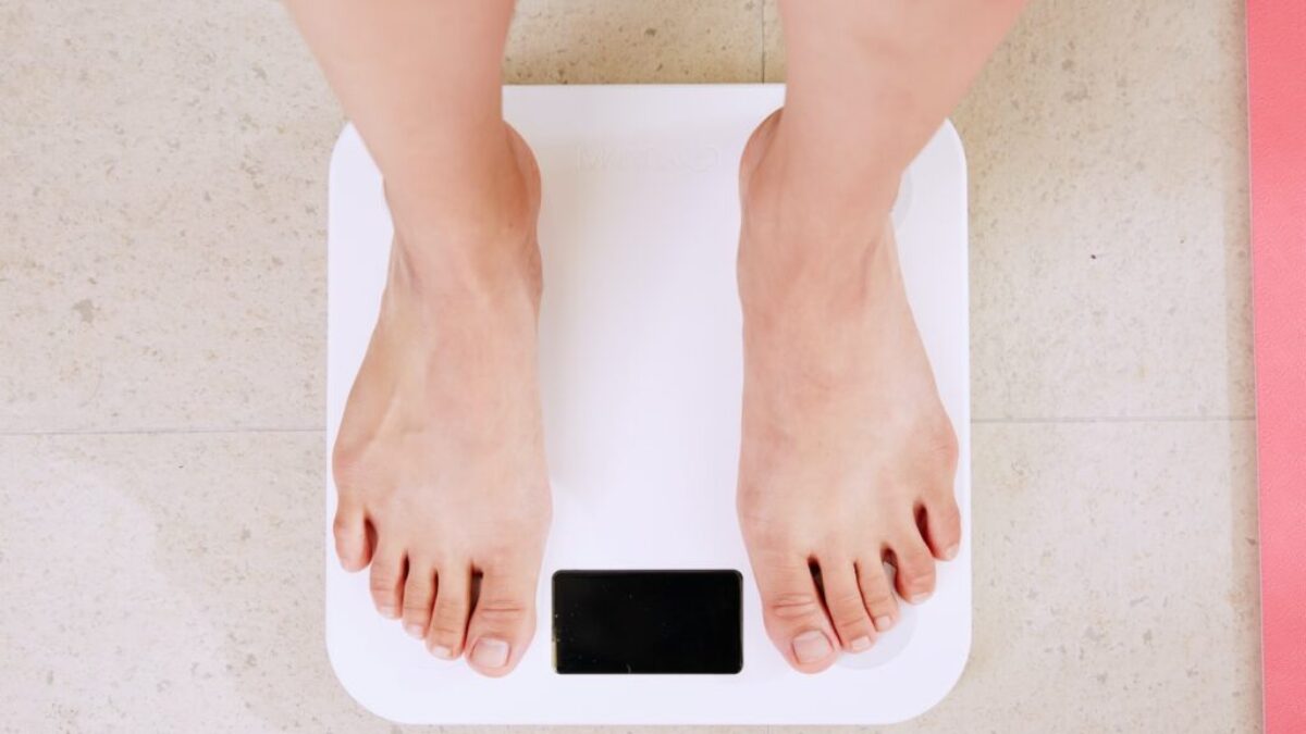 person standing on white digital bathroom scale