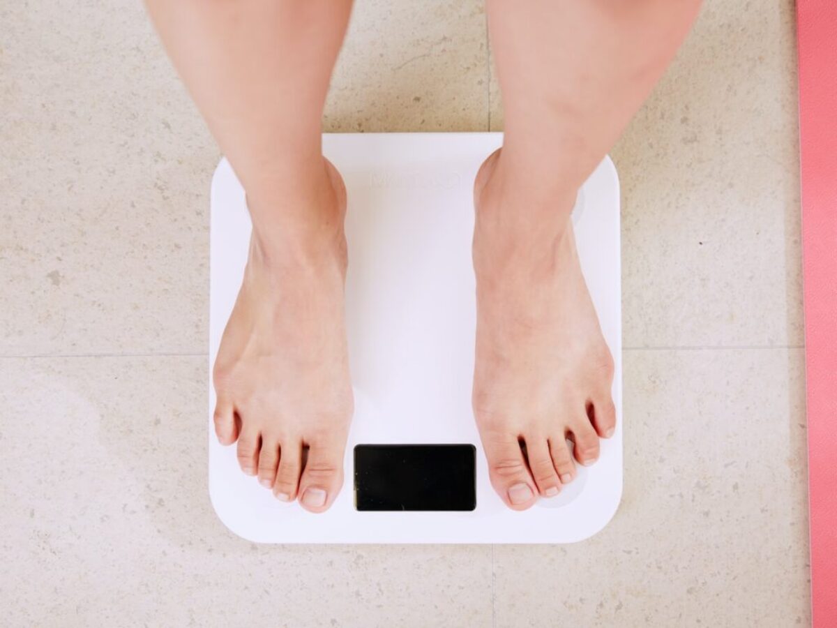person standing on white digital bathroom scale