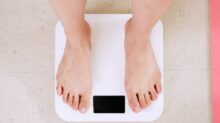 person standing on white digital bathroom scale