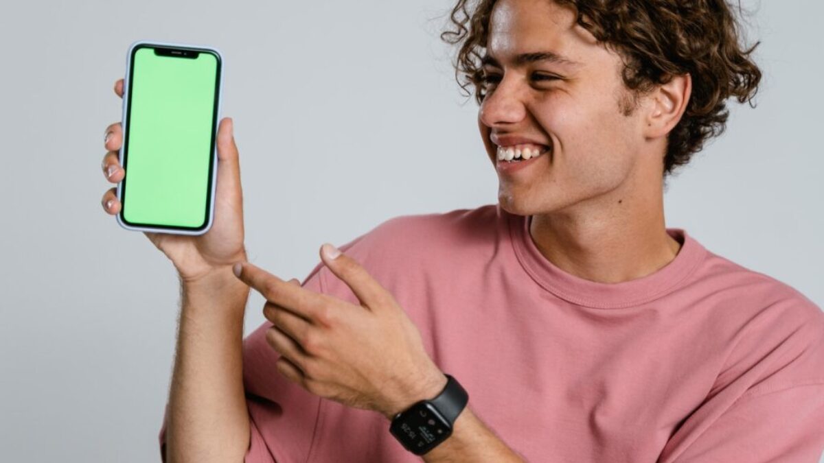 Man in Pink Crew Neck T-shirt Holding Blue Iphone Case