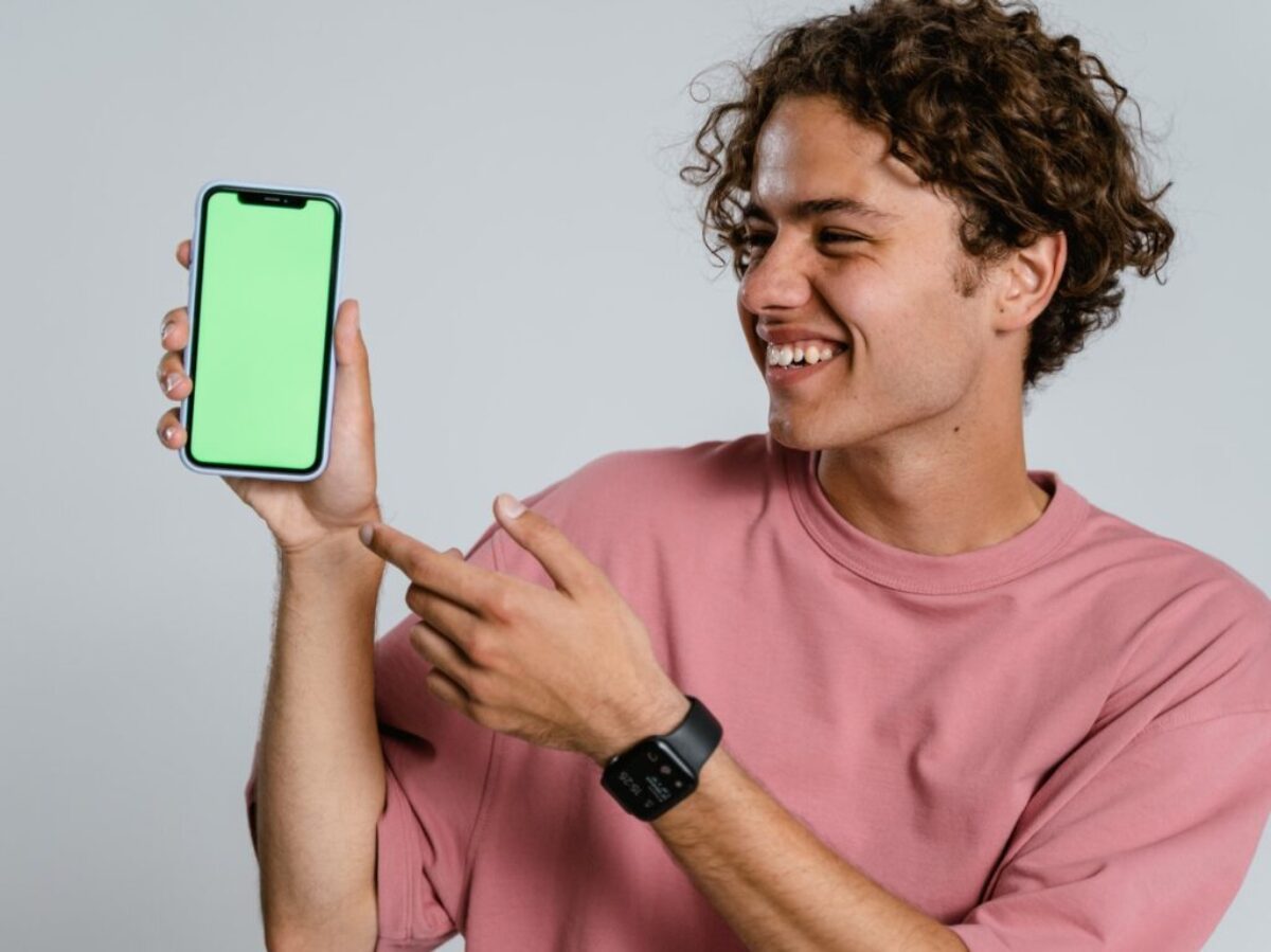 Man in Pink Crew Neck T-shirt Holding Blue Iphone Case