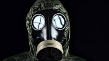 person in green and black gas mask